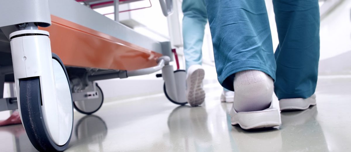 Medical staff moving patient through hospital corridor